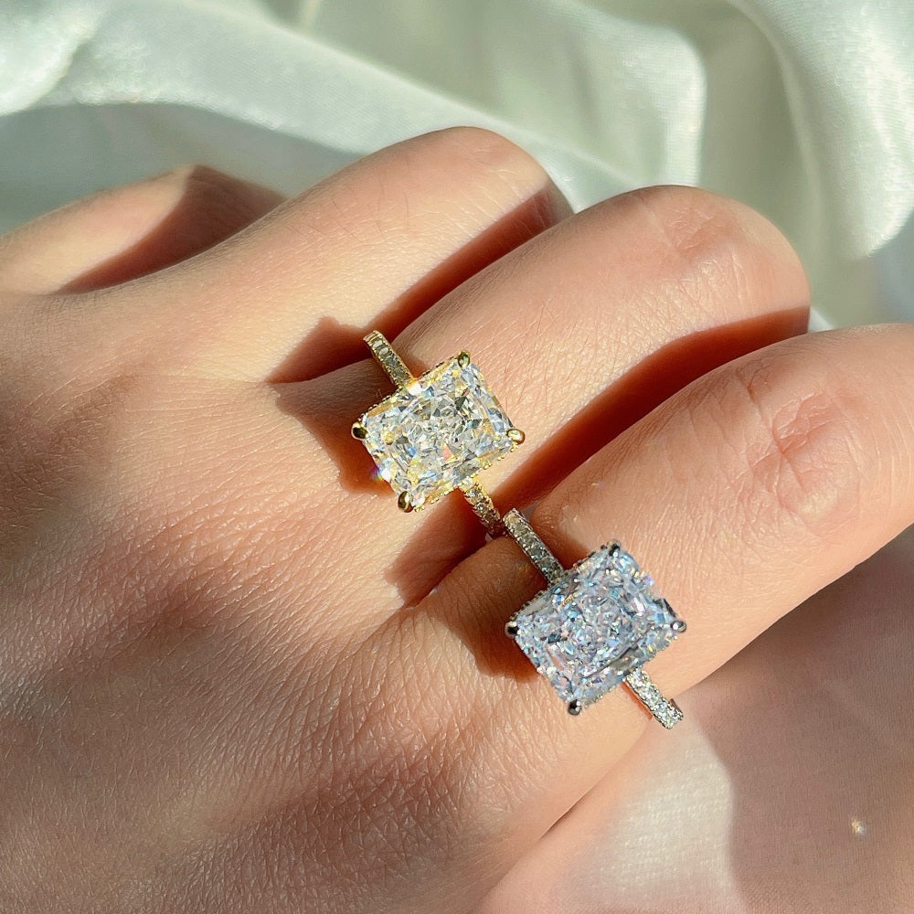 A silver & gold-colored band engagement ring featuring a large rectangle-shaped central stone with smaller stones around it