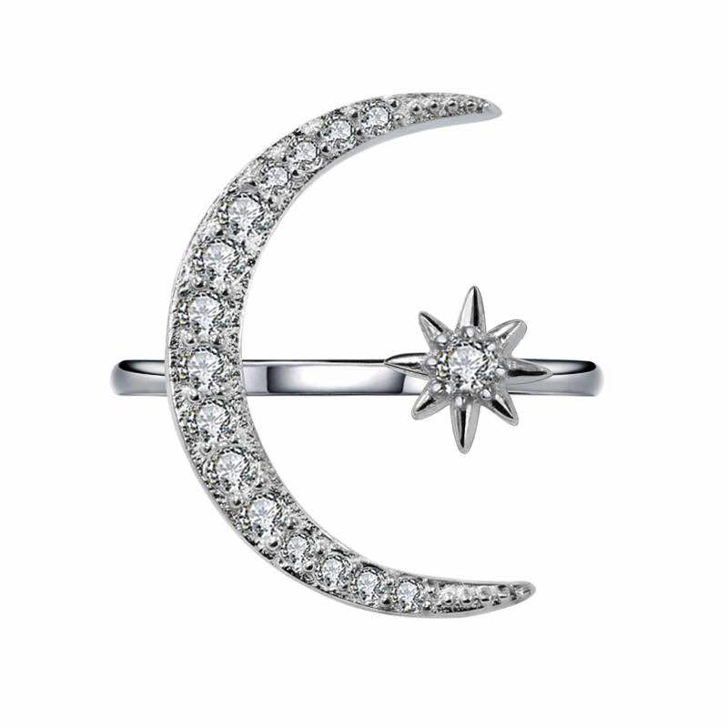 A silver-colored sterling silver ring featuring a crescent moon and a star design with sparkling stones set in the moon and star shapes.