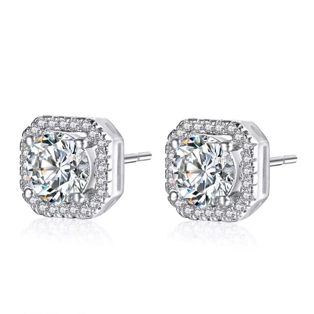 A pair of sterling silver earrings with a clear central gemstone surrounded by smaller stones in a square setting.